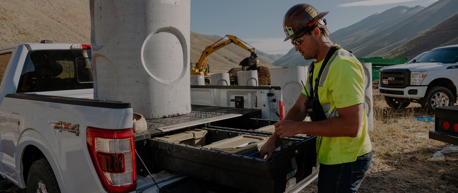 A construction worker retrieving gear out of his Drawer System effortlessly with a giant concrete pylon on top.