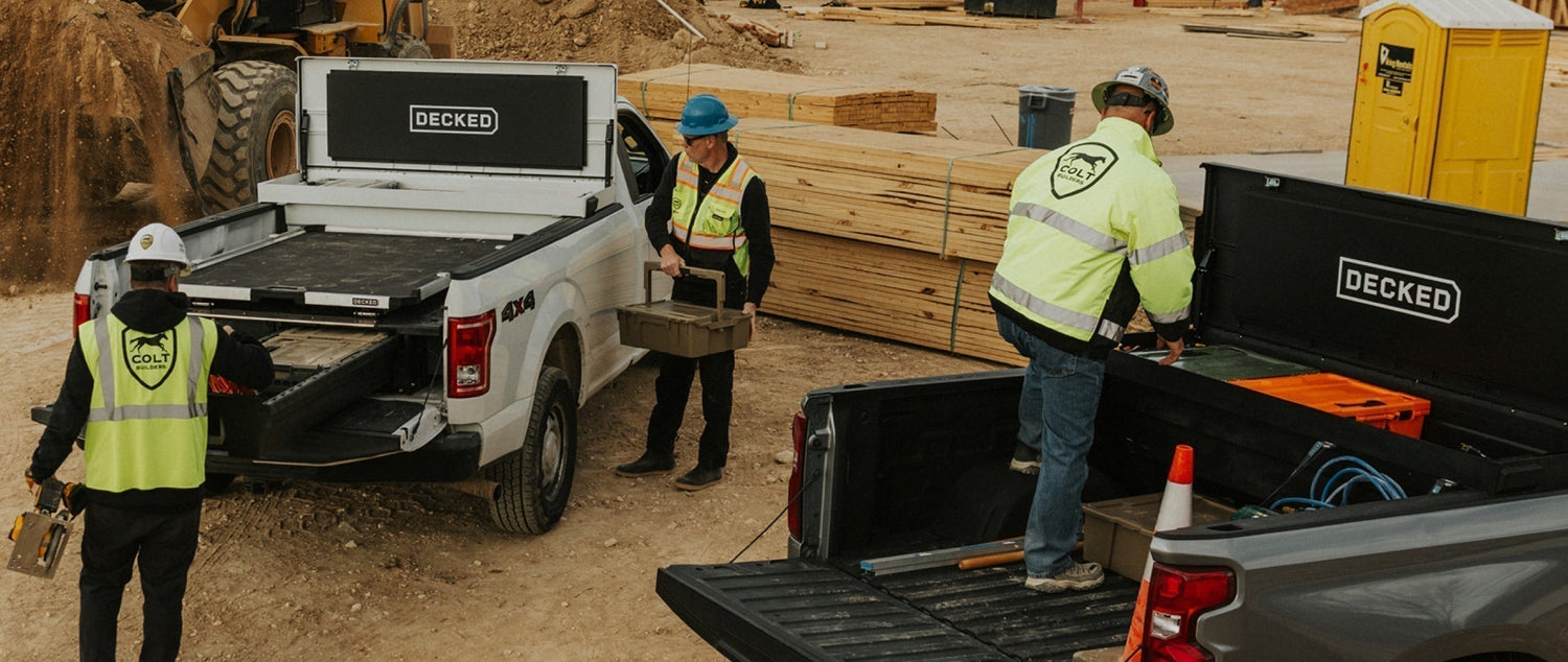 Three construction workers at a worksite using their DECKED toolboxes and bins.