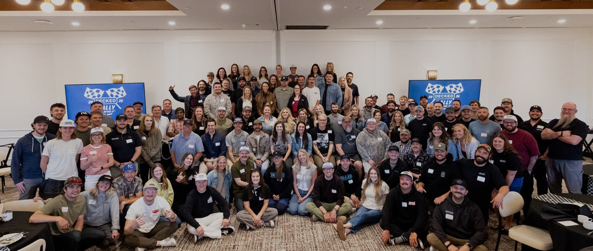 DECKED employees at the decked rally in a large conference room smiling for the camera.