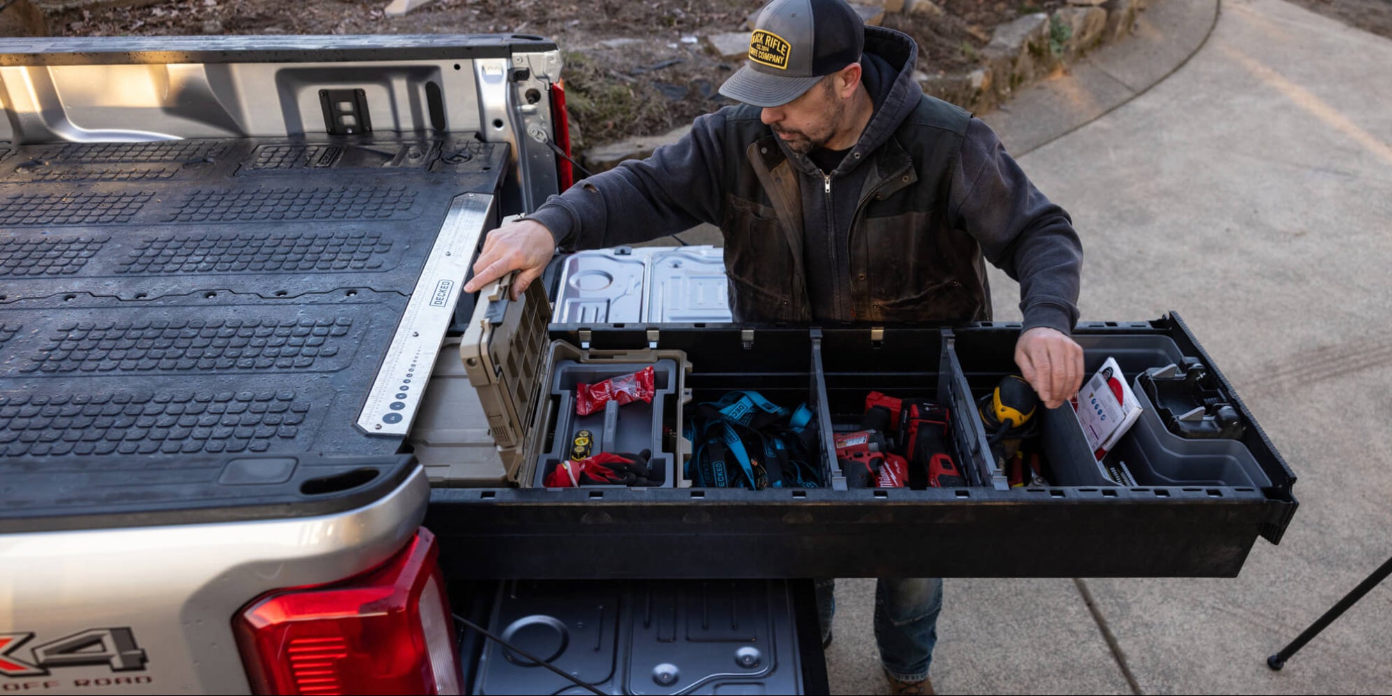 A man retrieving his organized Milwaukee tools from his Drawer System in his 8' bed truck.