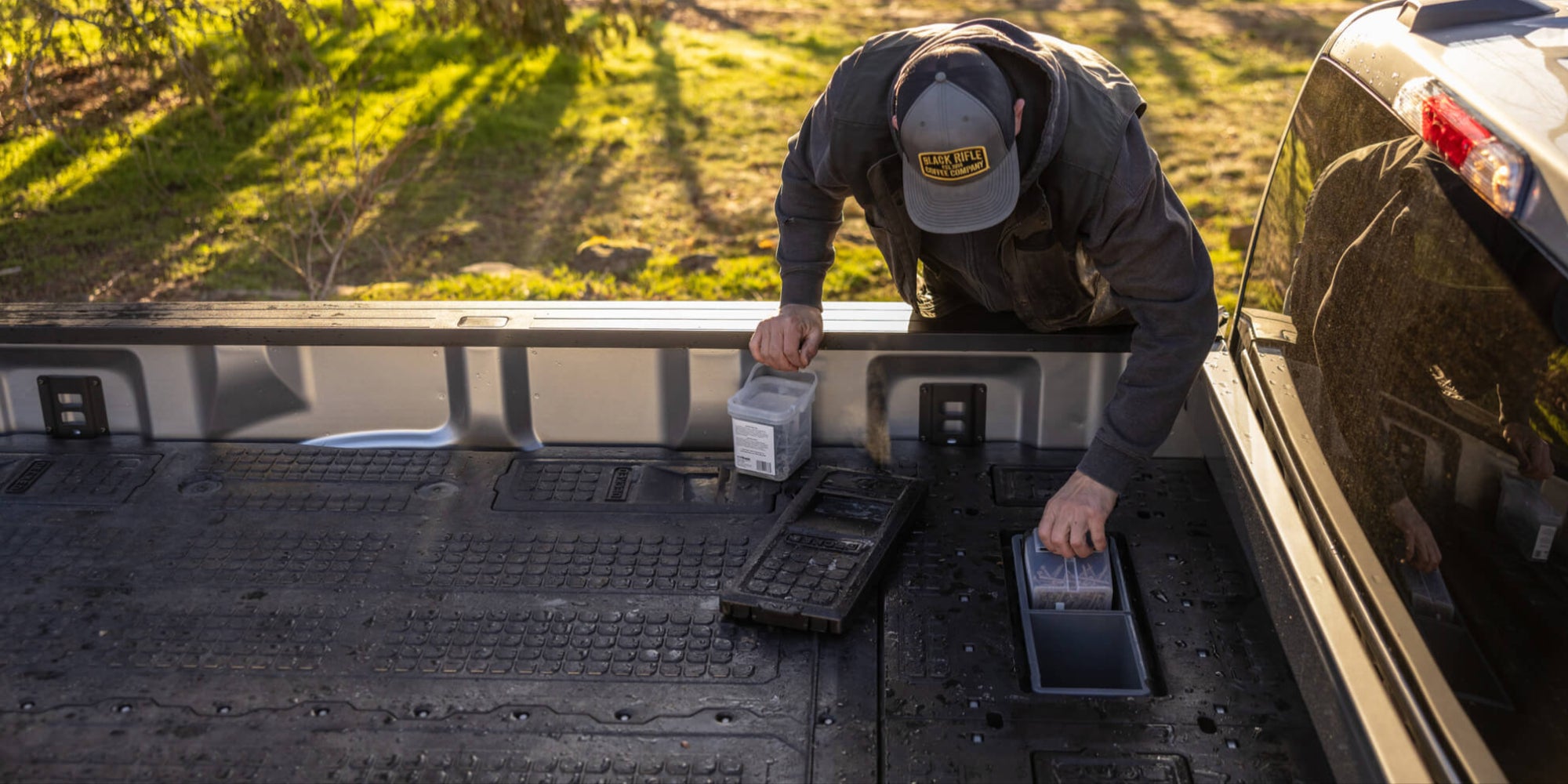 A man storing nails in the cab-side stash bins in his 8' Load Floor, part of the Drawer System for 8 foot truck beds.