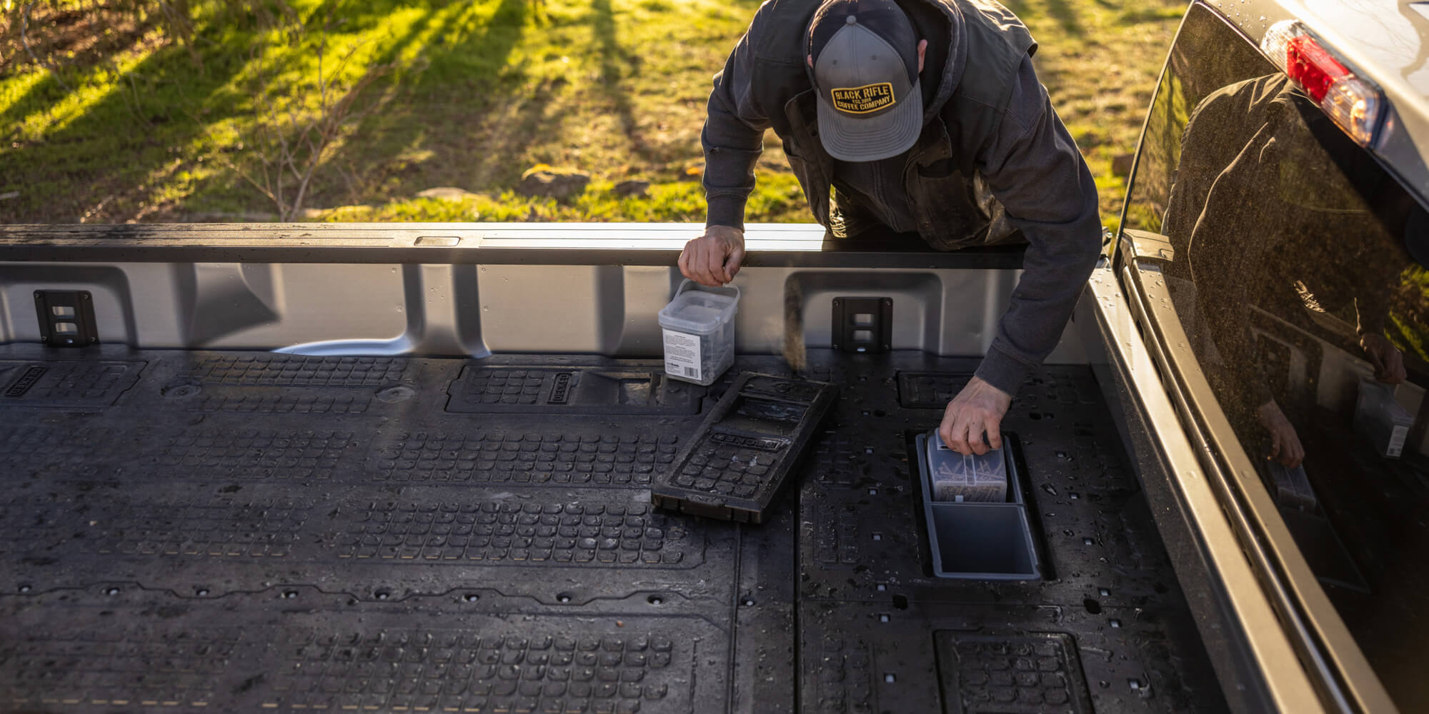 A man storing nails in the stash bins located in the 8 foot load floor that closed out the cab-side gap of his Drawer System.