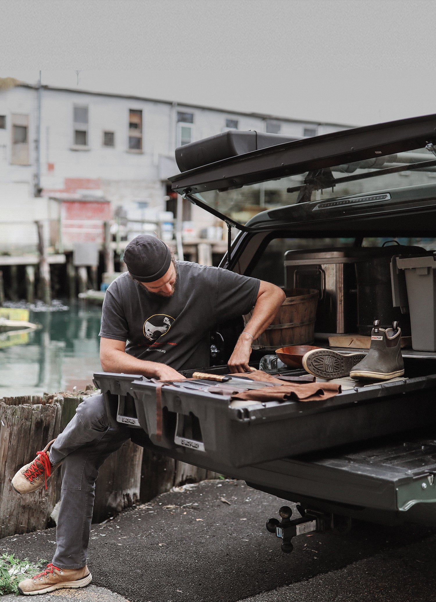man sitting on his open tailgate reaching for something in his drawer system