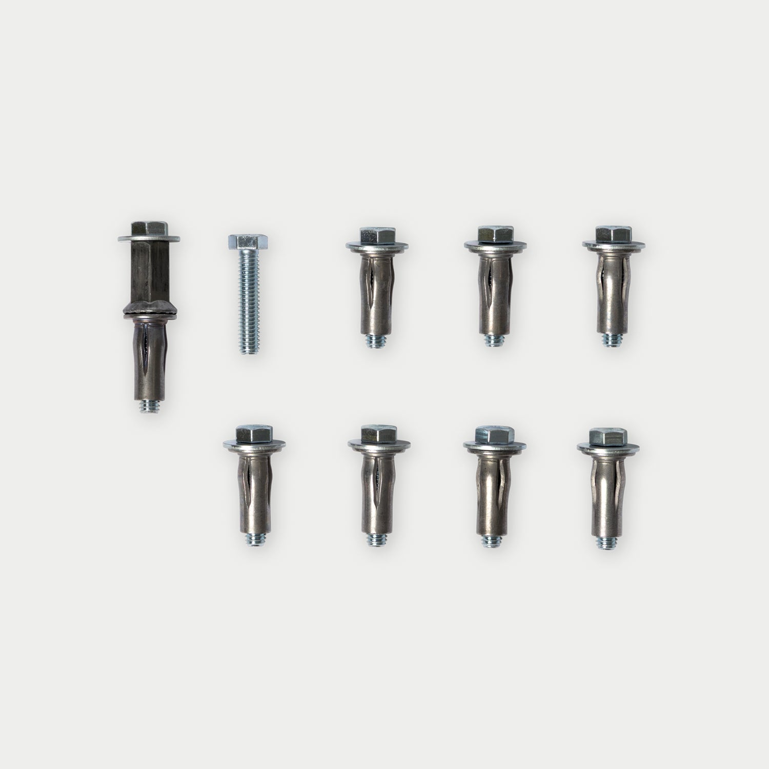 A set of eight metal wall anchors with matching hex bolts, arranged on a light gray background.