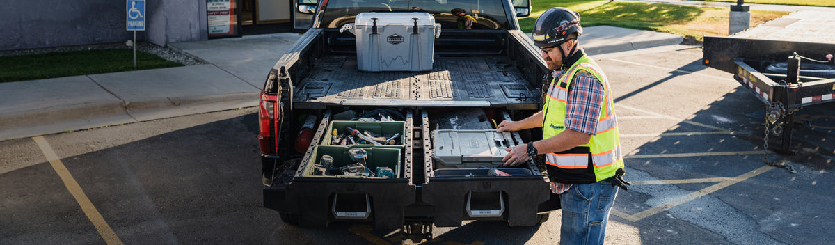 Construction worker organizing tools and DECKED cases inside open Drawer System drawers.