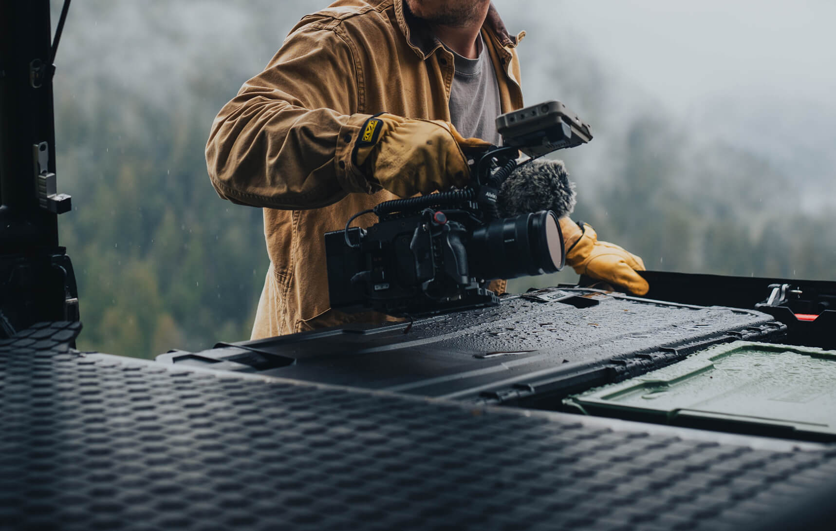 Person in a brown jacket and gloves grabbing a camera out of their Drawer System.
