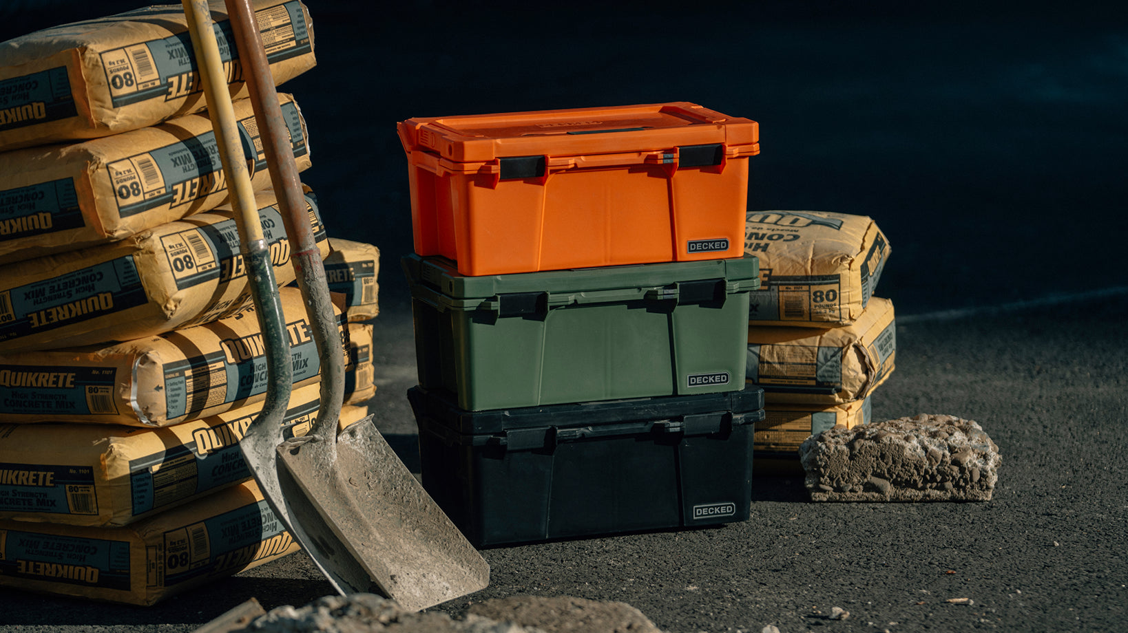 DECKED sixer cases stacked next to concrete mix.