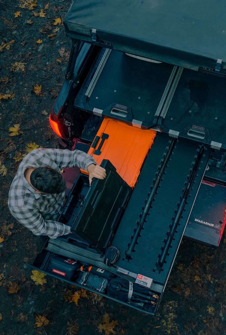 Person organizing tools in a large Drawer System toolbox outdoors.