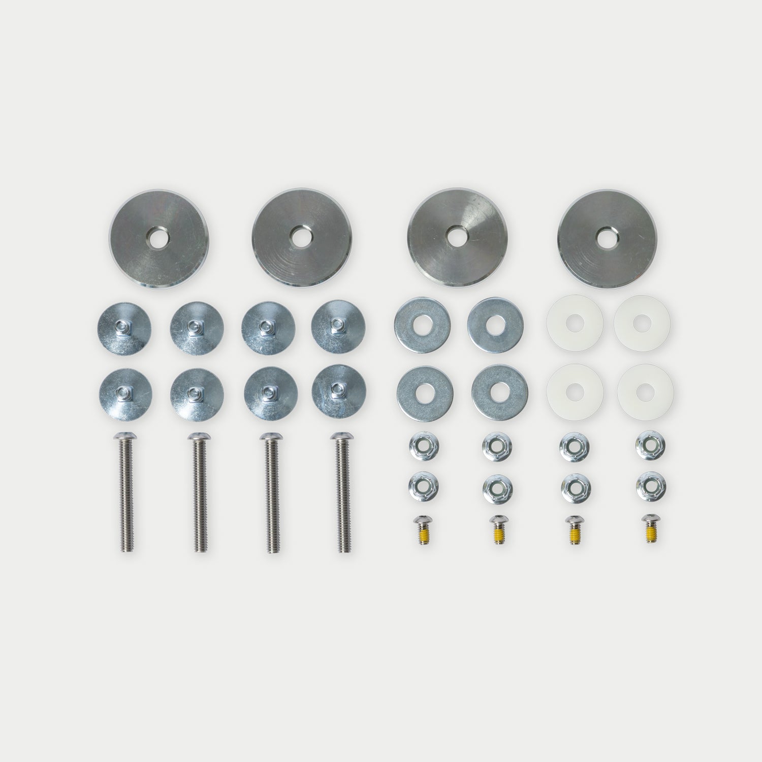 A hardware mounting kit laid out on a light gray background, including round metal washers, flat washers, screws, bolts, nuts, and white plastic inserts.