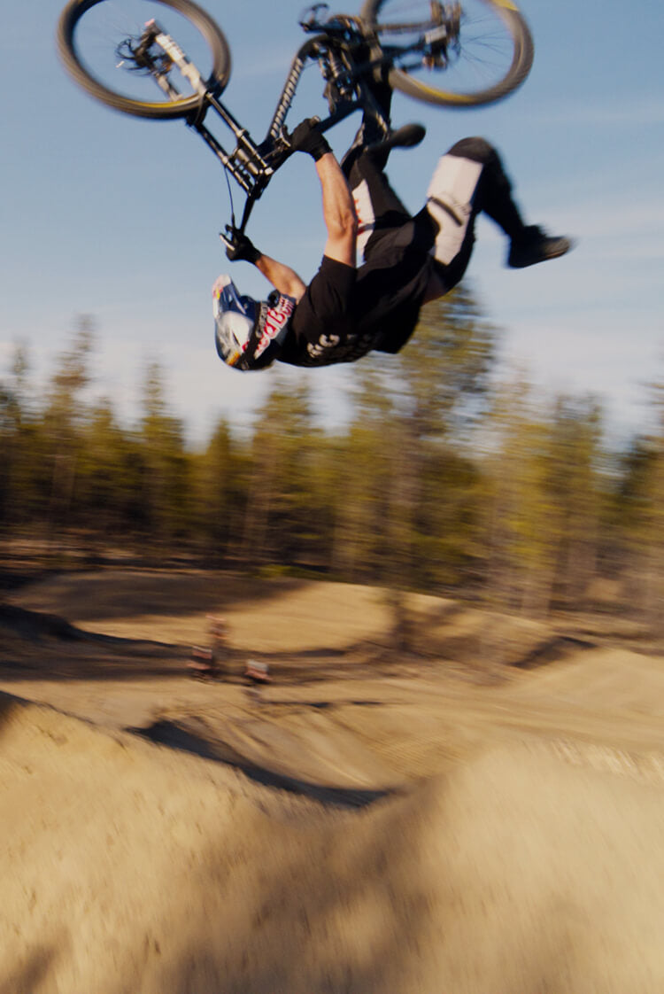 In the air, upside down, with only one foot on the bike? That’s just a typical day on the back yard jumps for Bend, Oregon freerider Carson Storch.