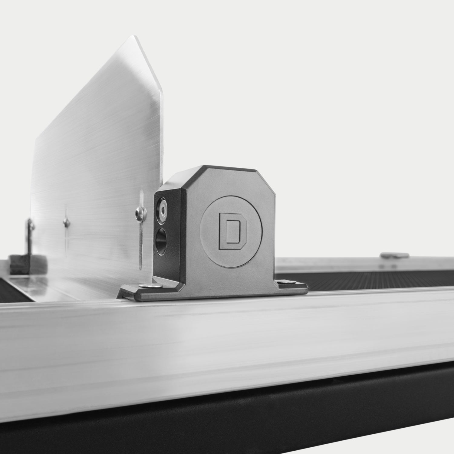 A close up of the mounting point of a Crossbar with a Divider to the side rail of the CargoGlide. You can see the Crossbar and Divider spanning the width of the CargoGlide in the background.