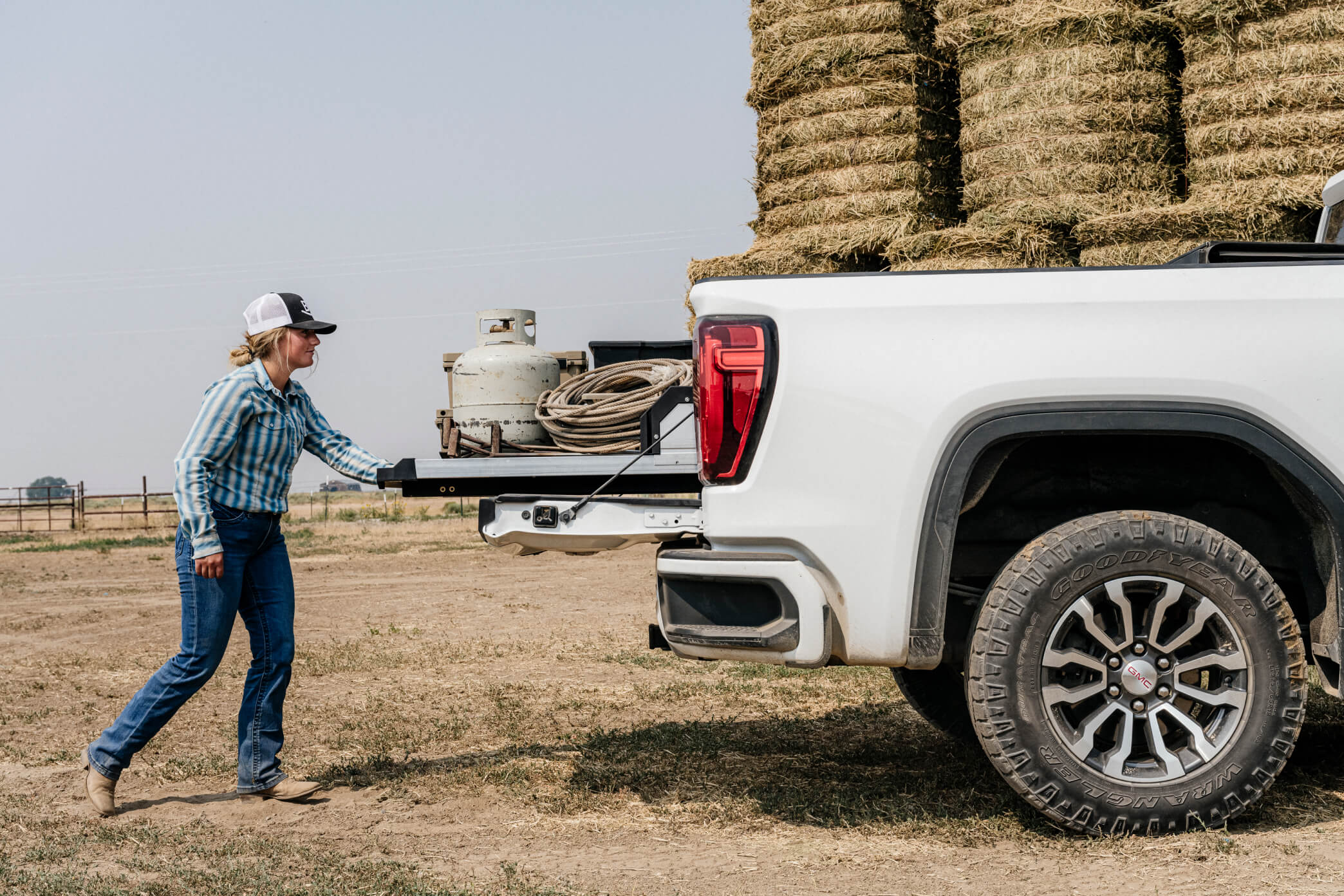 A woman rancher retrieving branding equipment from her CargoGlide system as she prepares to brand her cattle.