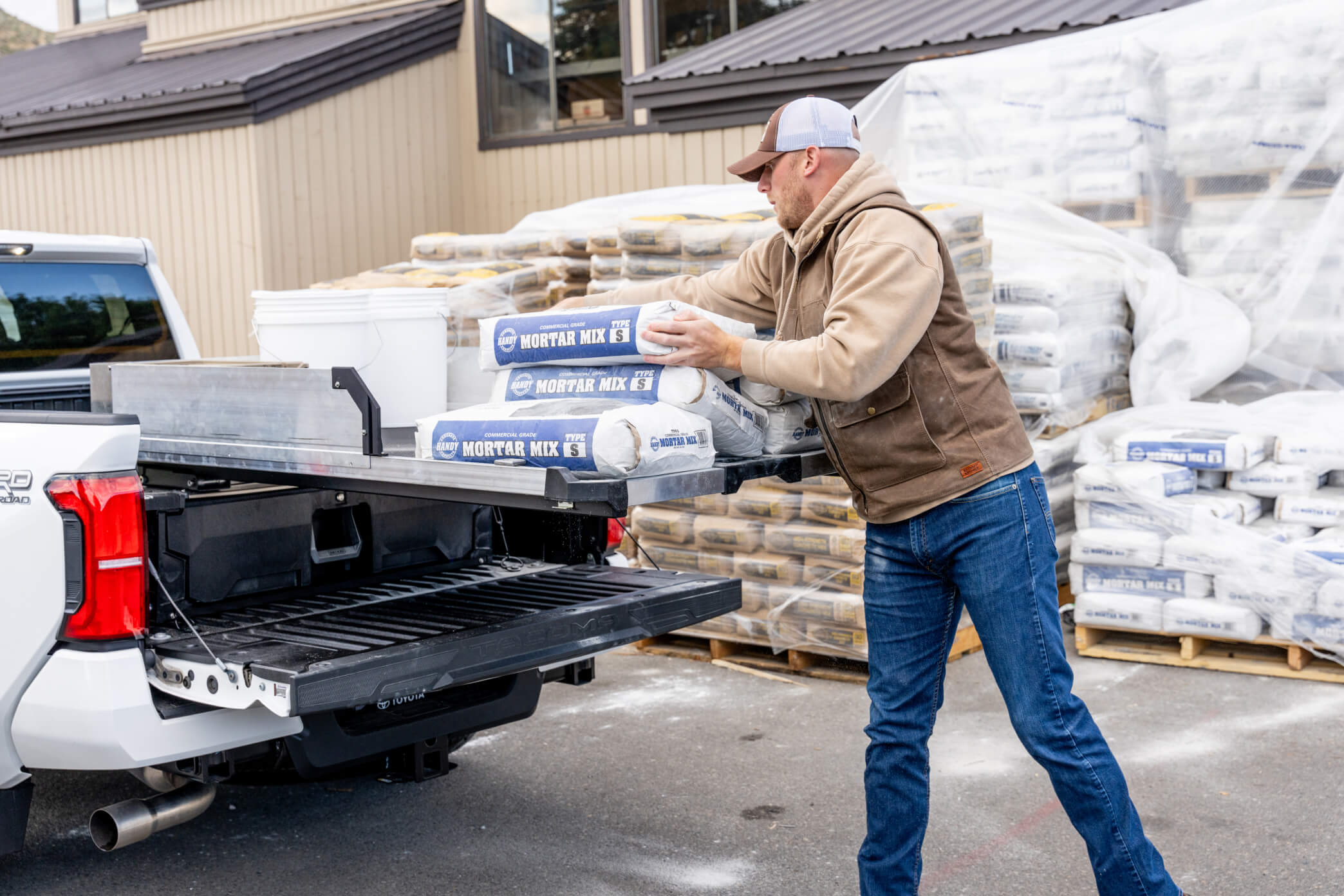 A man loading 80lb bags of mortar mix onto his CargoGlide.