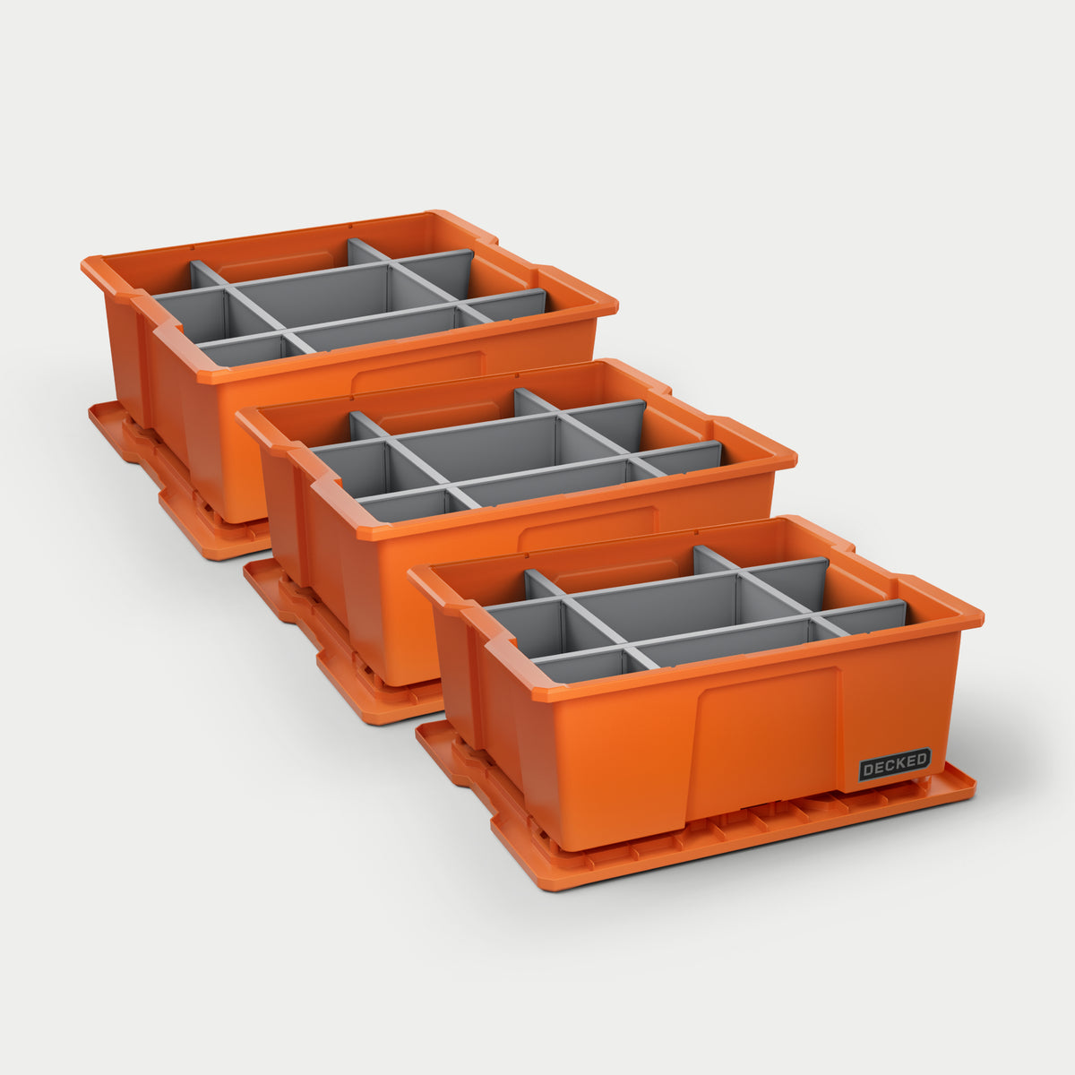 Three orange DECKED payloader bins with grey POD divider systems installed in all of them on a white background.