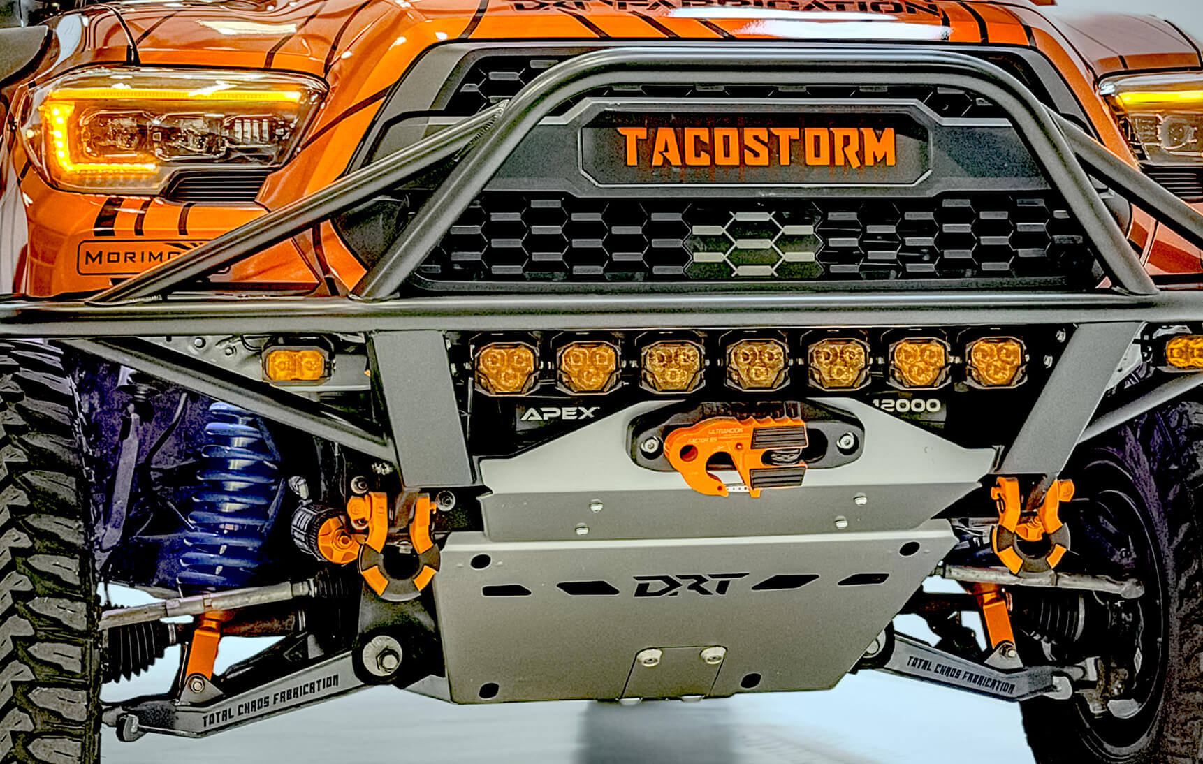 Close-up of a vehicle bumper with 'TACOSTORM' branding and various components.