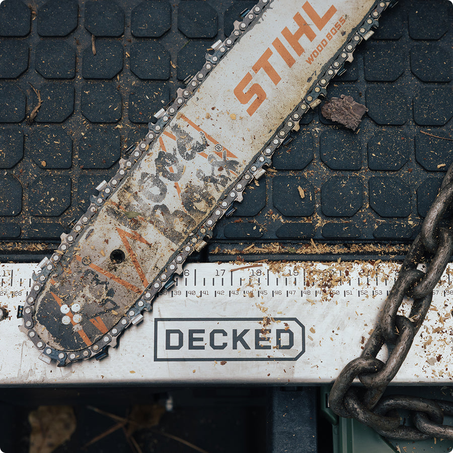 Chainsaw and logging chain resting on a DECKED Drawer System at a timber worksite.
