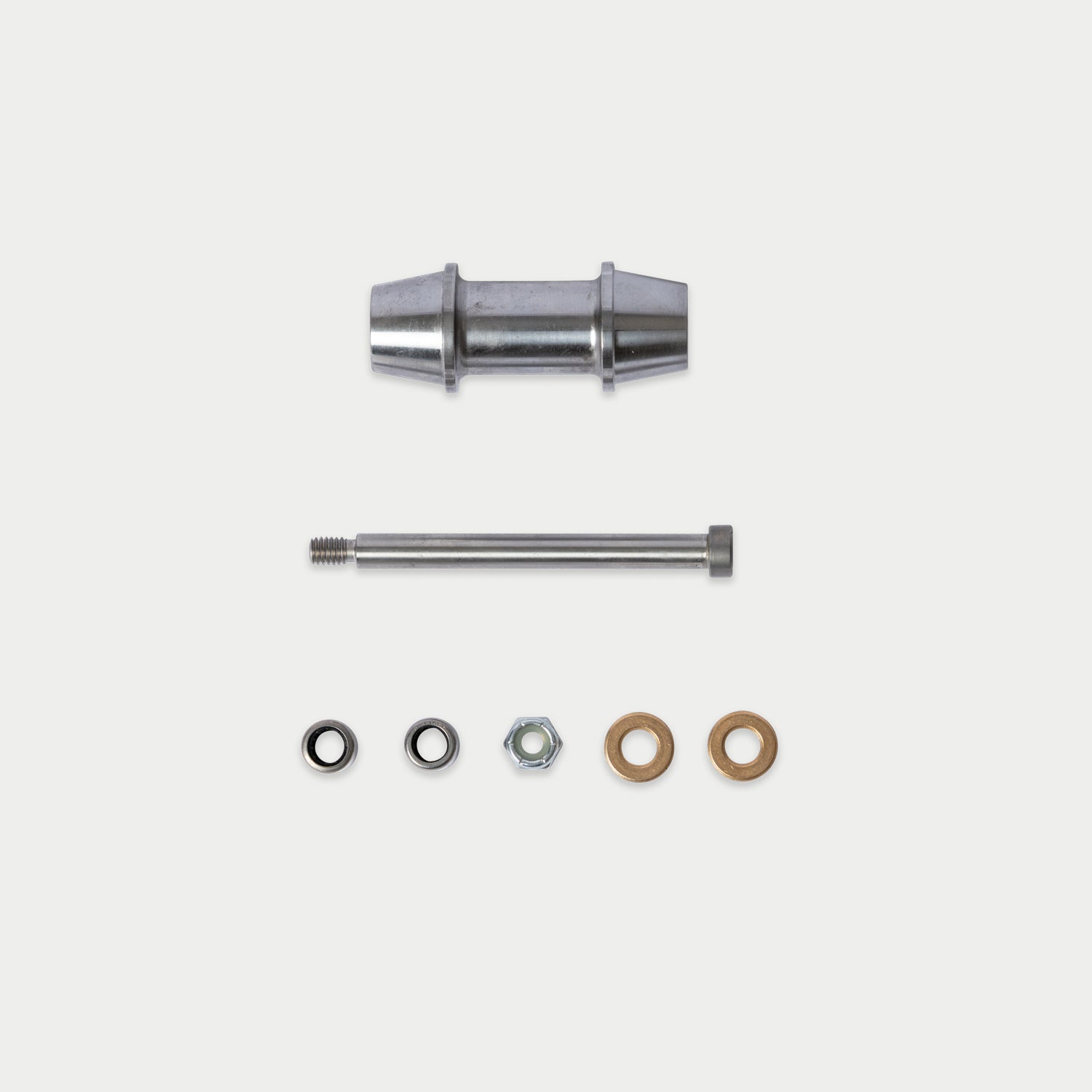 A metal hardware kit containing a cylindrical metal sleeve, a threaded metal rod, a silver hex nut, and two flat washers in silver and bronze, arranged on a light gray background.