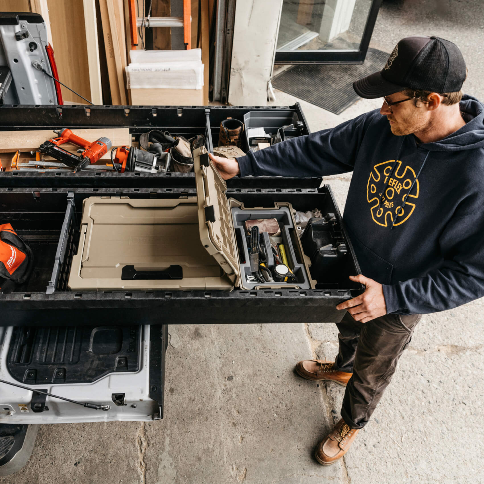 A man retrieving tools from a D-co Sixer Case that is stored neatly inside of his Drawer System.