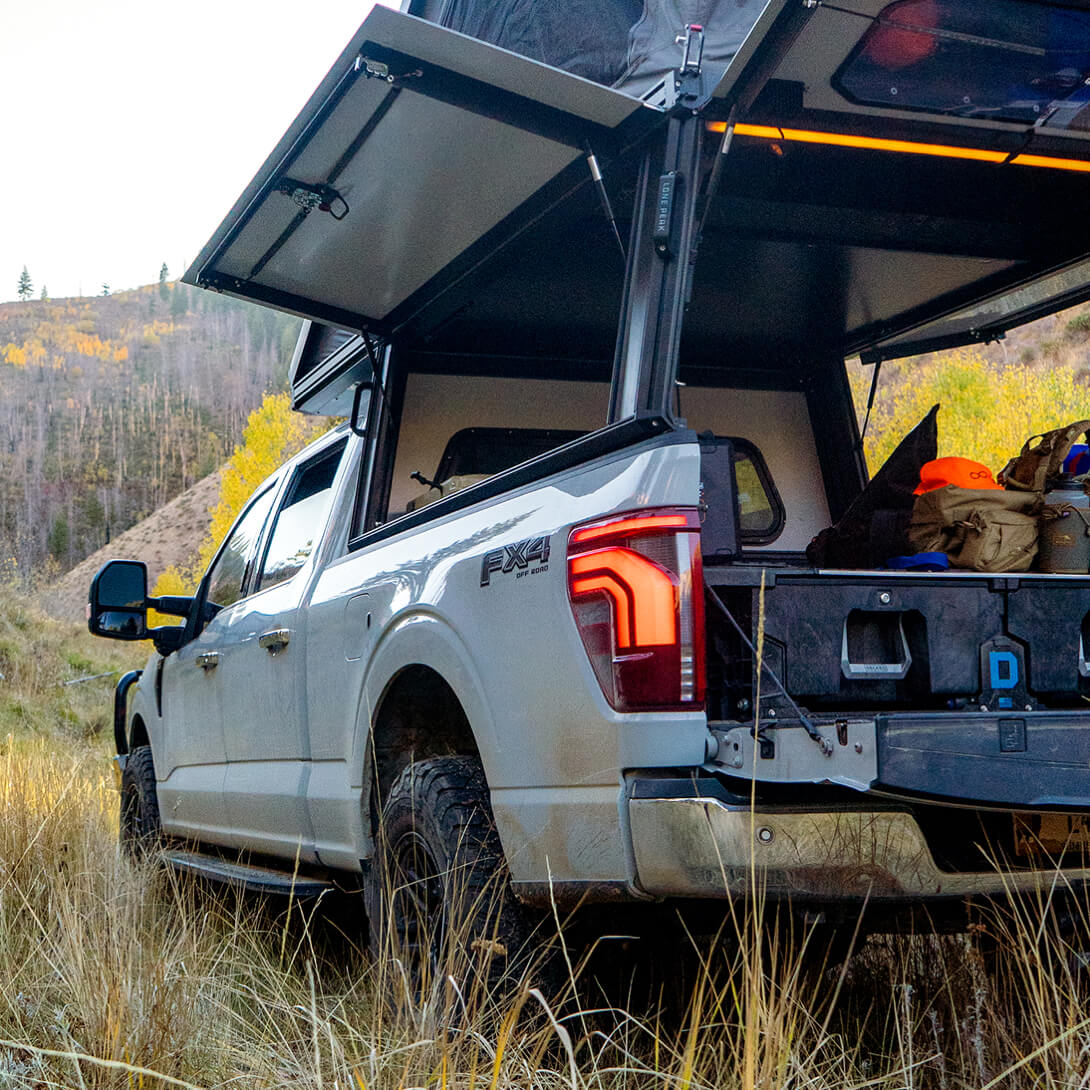 Ford F-250 Lariat truck with an open cargo area and a DECKED Drawer System in a natural setting