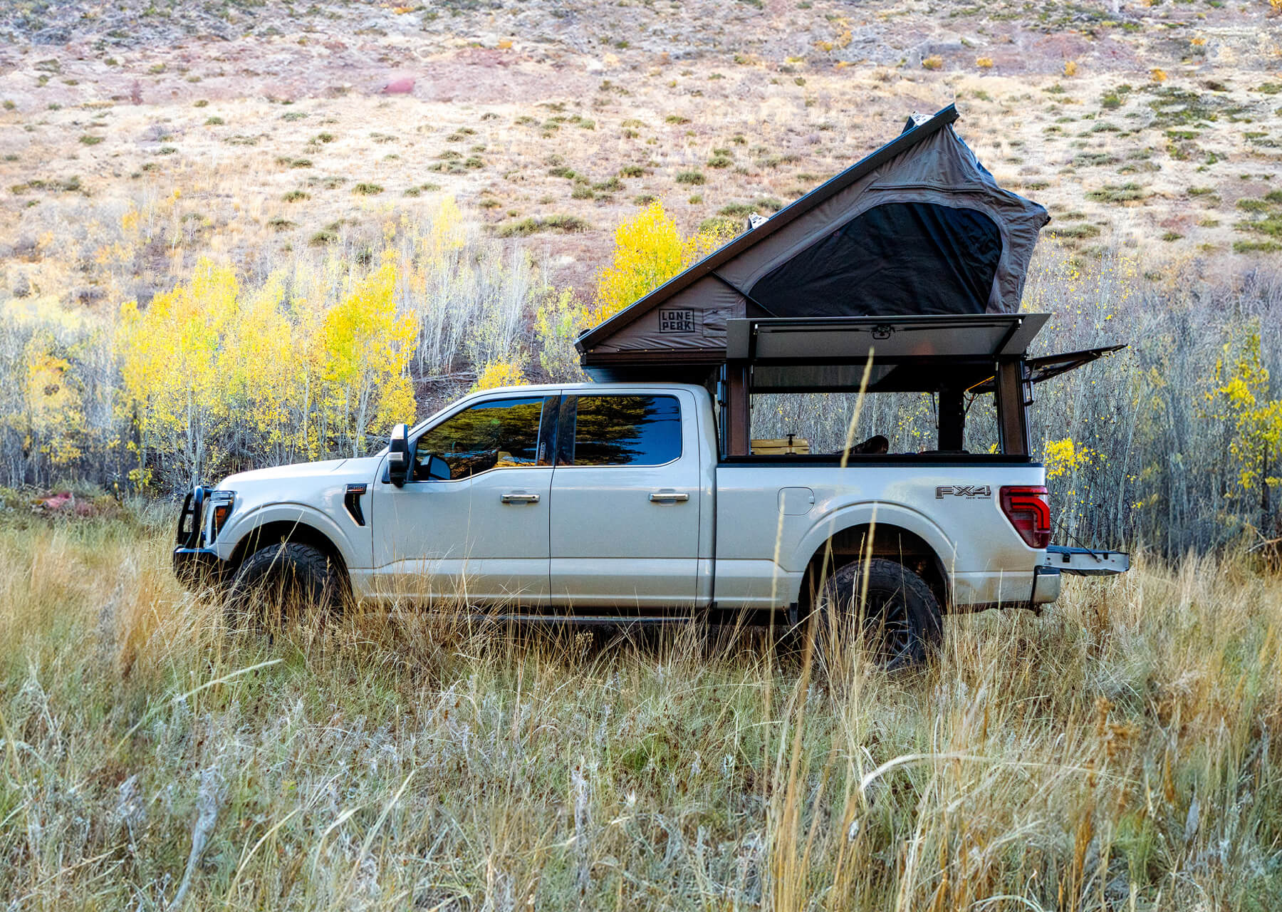 Ford F-250 Lariat truck with a roof tent in a natural landscape