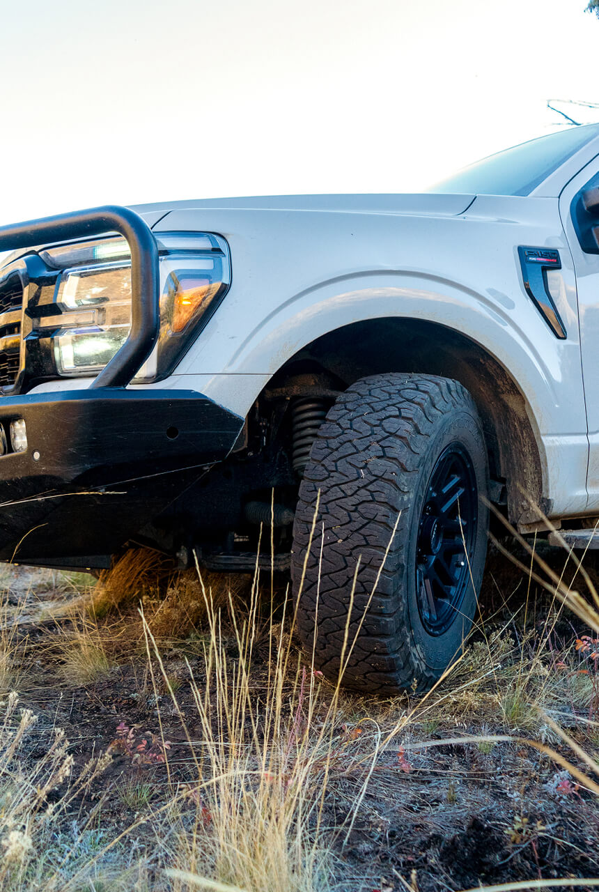 Ford F-250 Lariat truck with large off-road tires in a natural setting