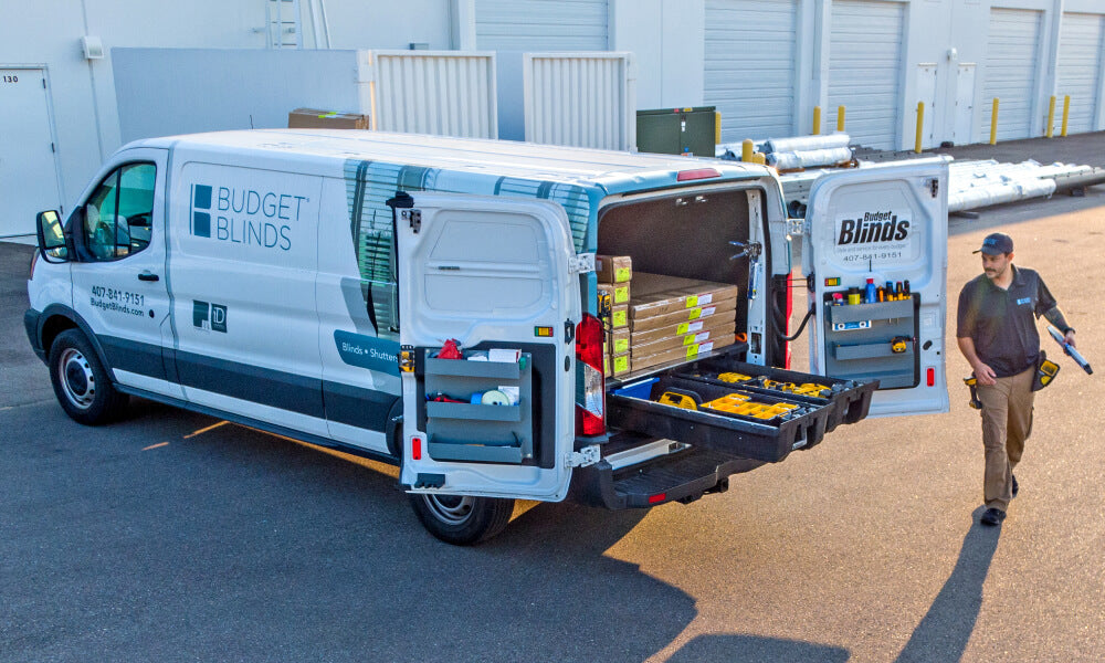 Back of cargo van with drawers open and man walking towards it