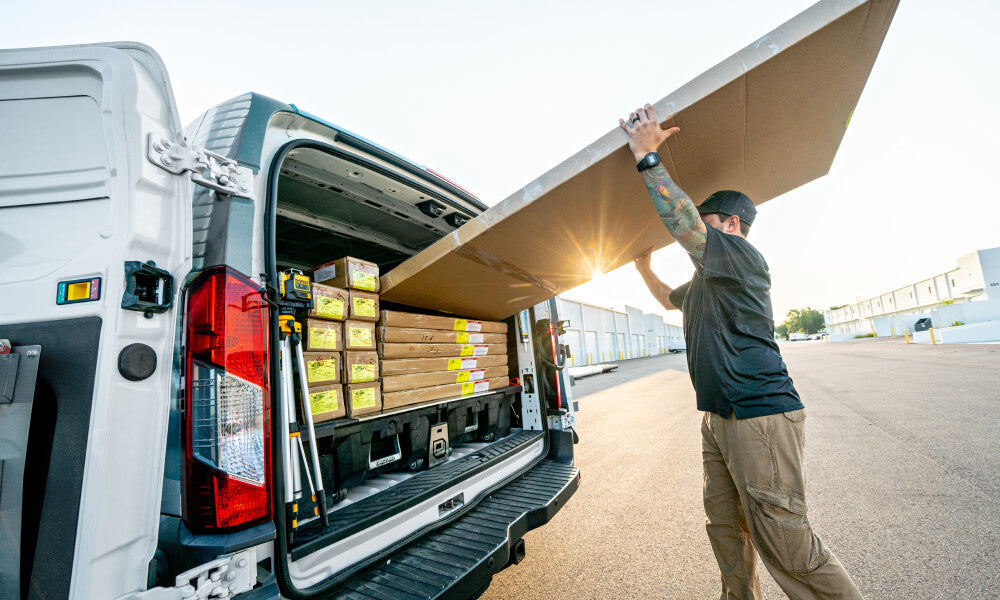 man putting a large box into his cargo van