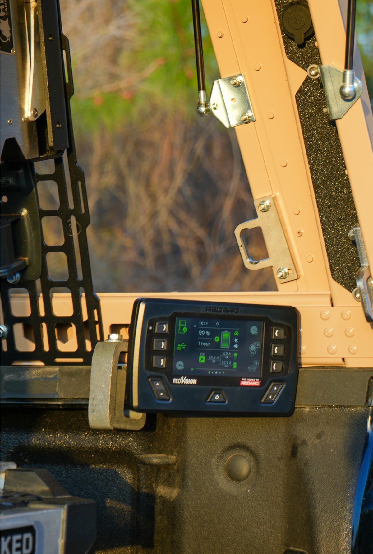 Vehicle power management display mounted inside a truck canopy, showing battery status and electrical system monitoring.