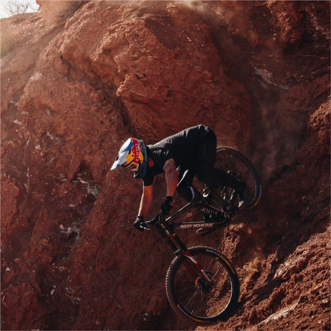 Carson Storch racing down a steep track in the red rocks.