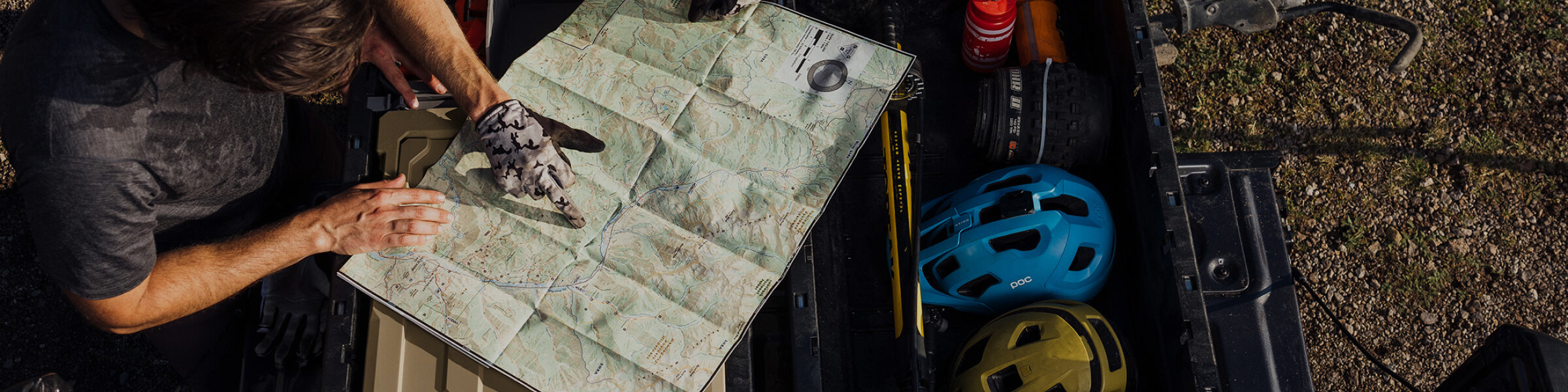 Person pointing to a location on a map planning a mountain bike ride
