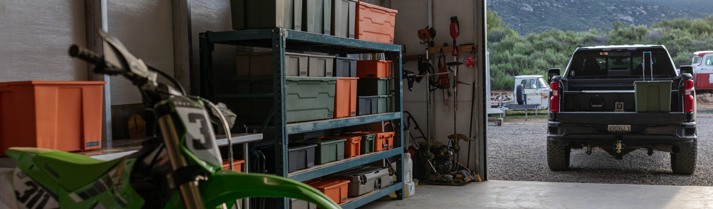 Garage with tools, storage shelves, and a motorcycle.