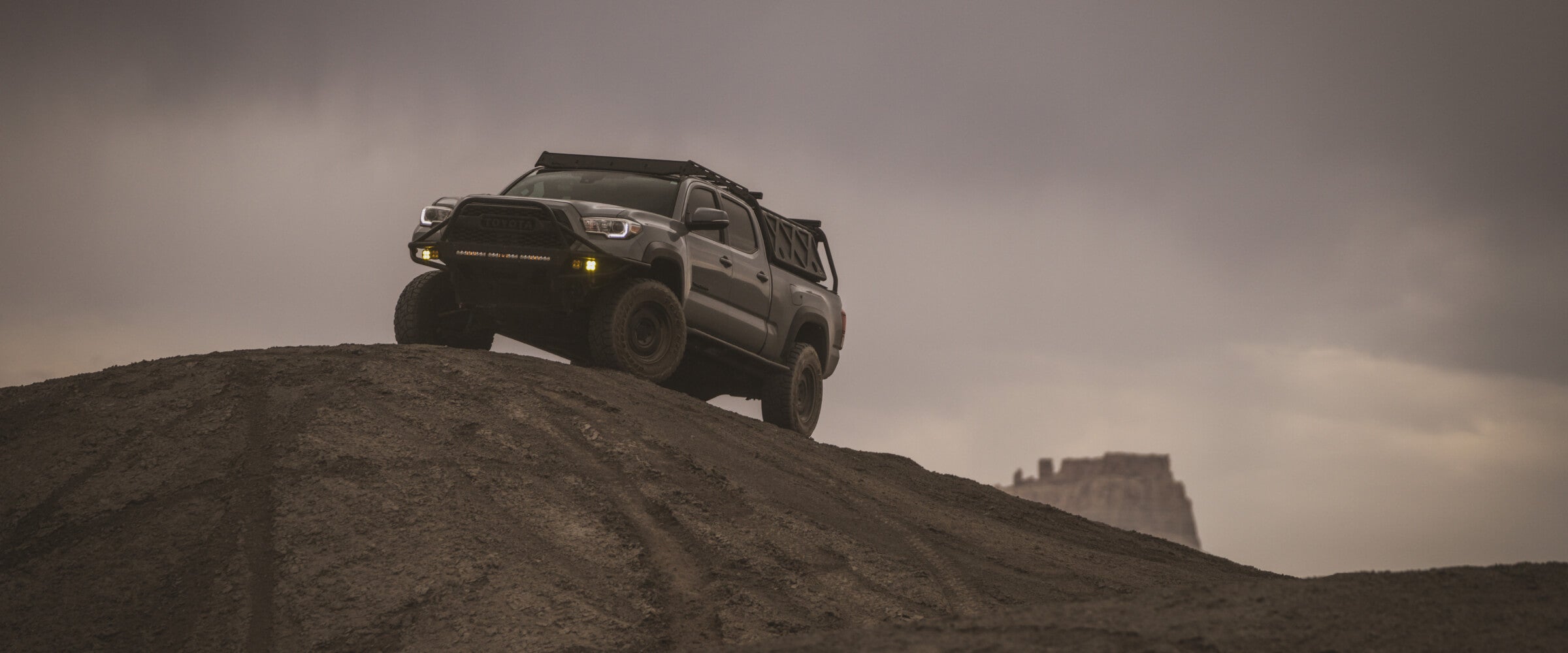 truck driving up a hill in the desert