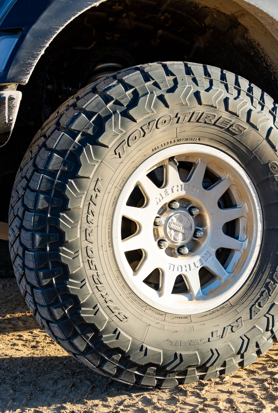 Close-up of a Toyo tire with tread pattern on a sandy surface