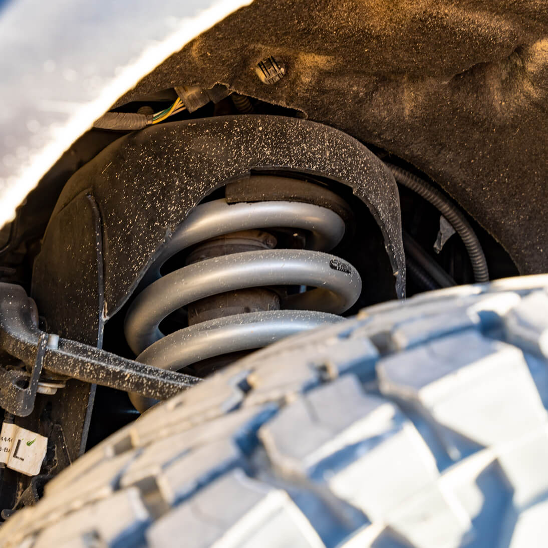 Close-up of a car suspension system with a focus on the coil spring.