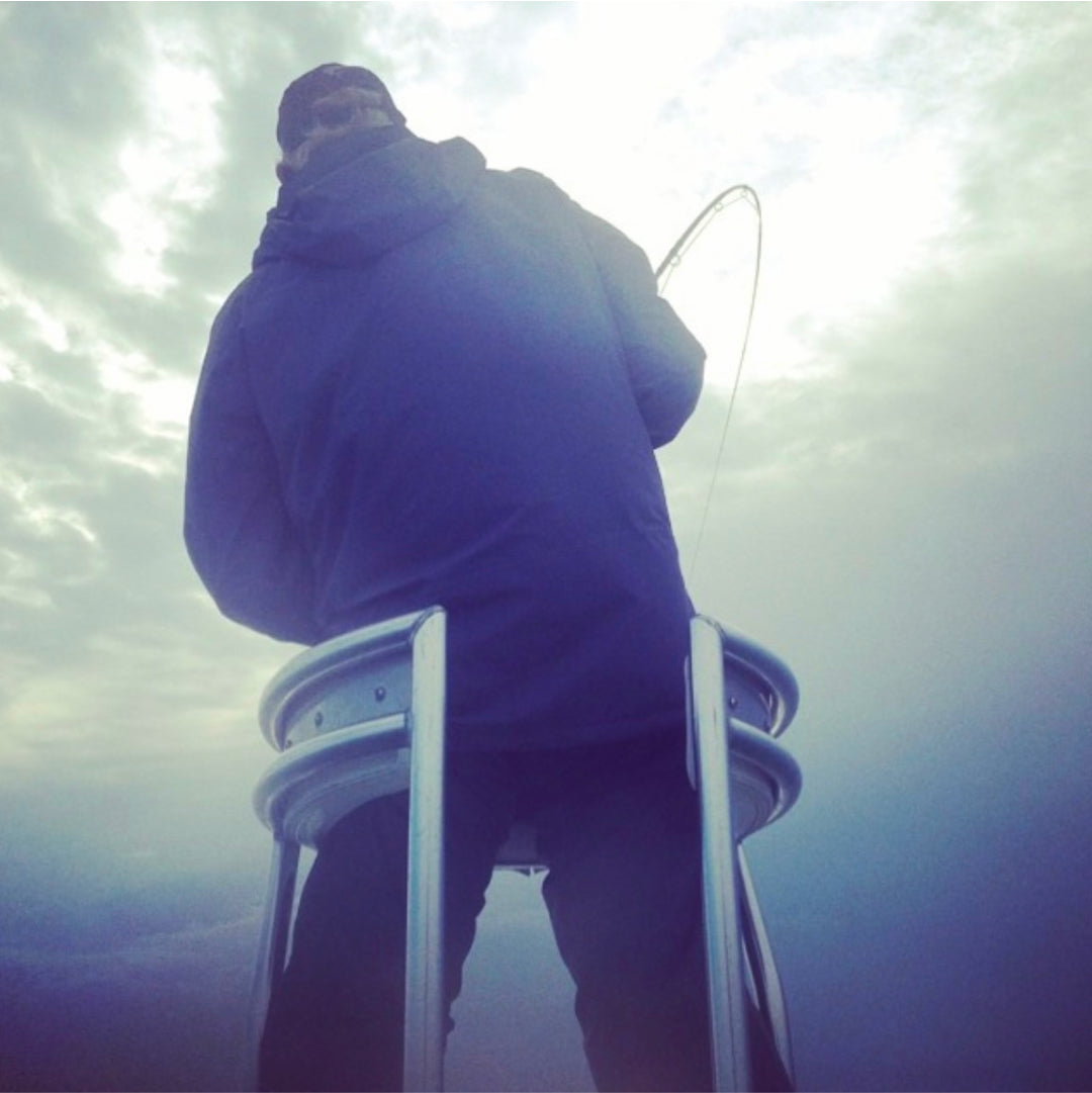 David Mangum pulling up on his fishing rod, which looks to have a big fish on the line.
