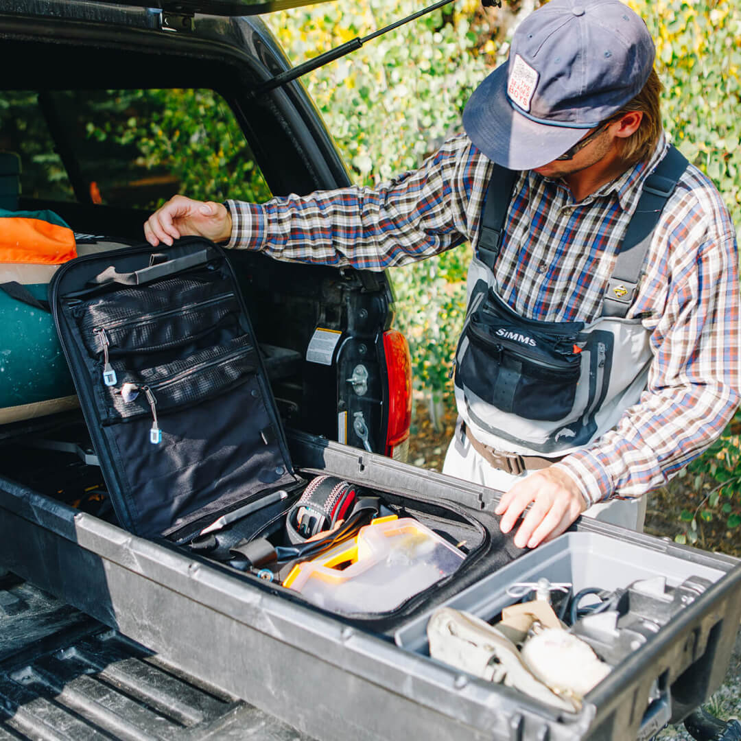 Man opening a Black D-bag inside a Drawer System to grab fishing gear