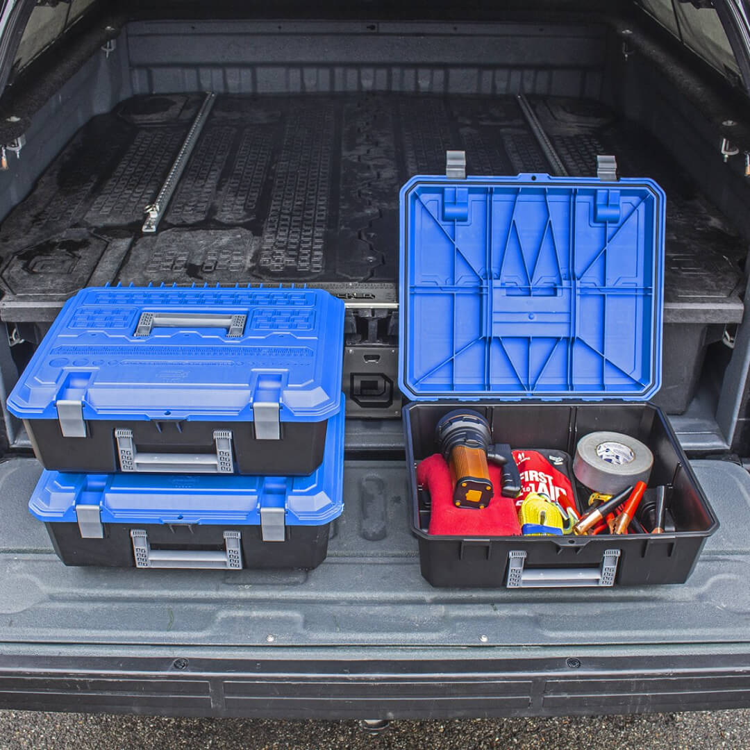 Blue D-boxes sitting on a tailgate storing various gear