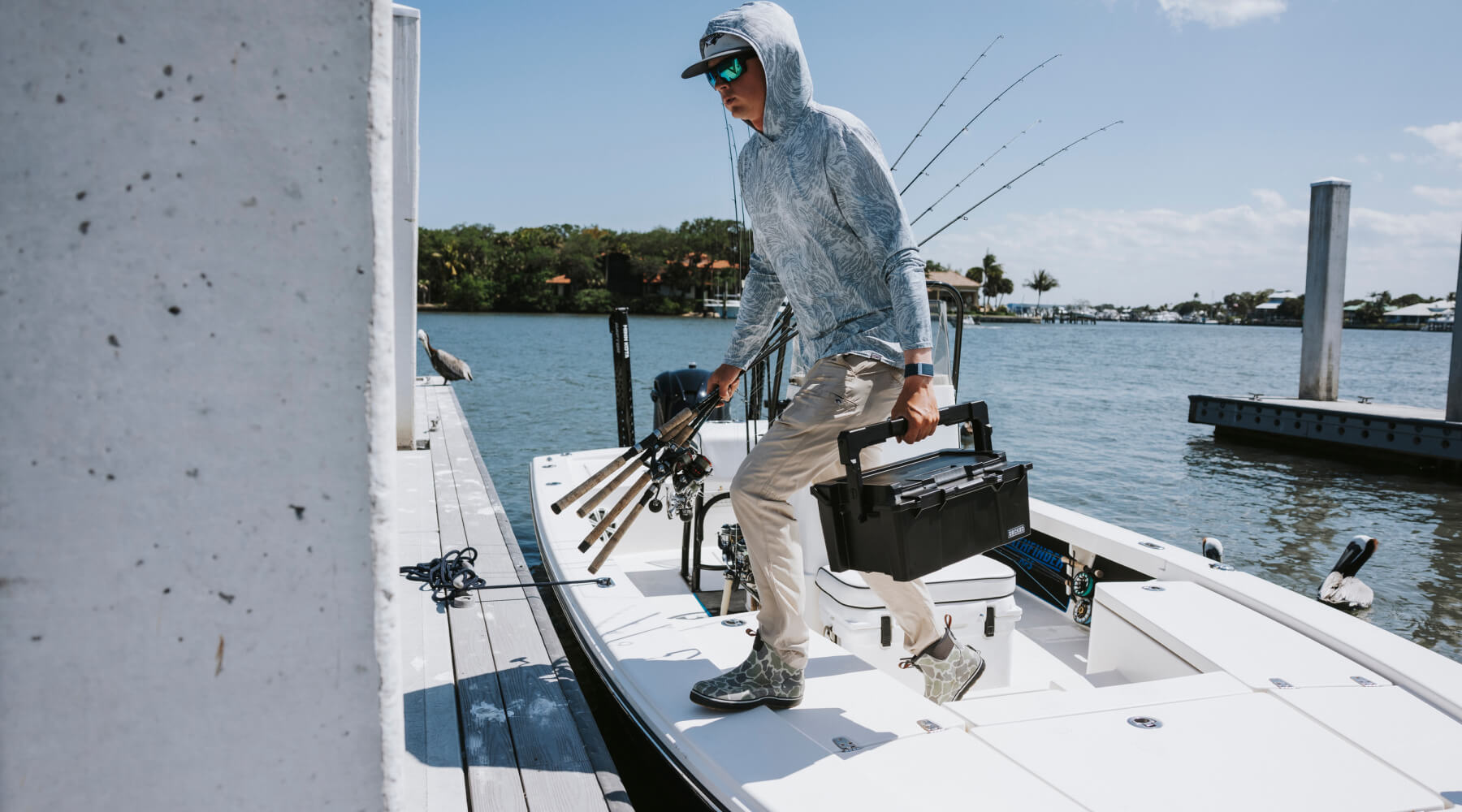 A man carrying his black Sixer D-co Case full of fishing gear off of his boat.