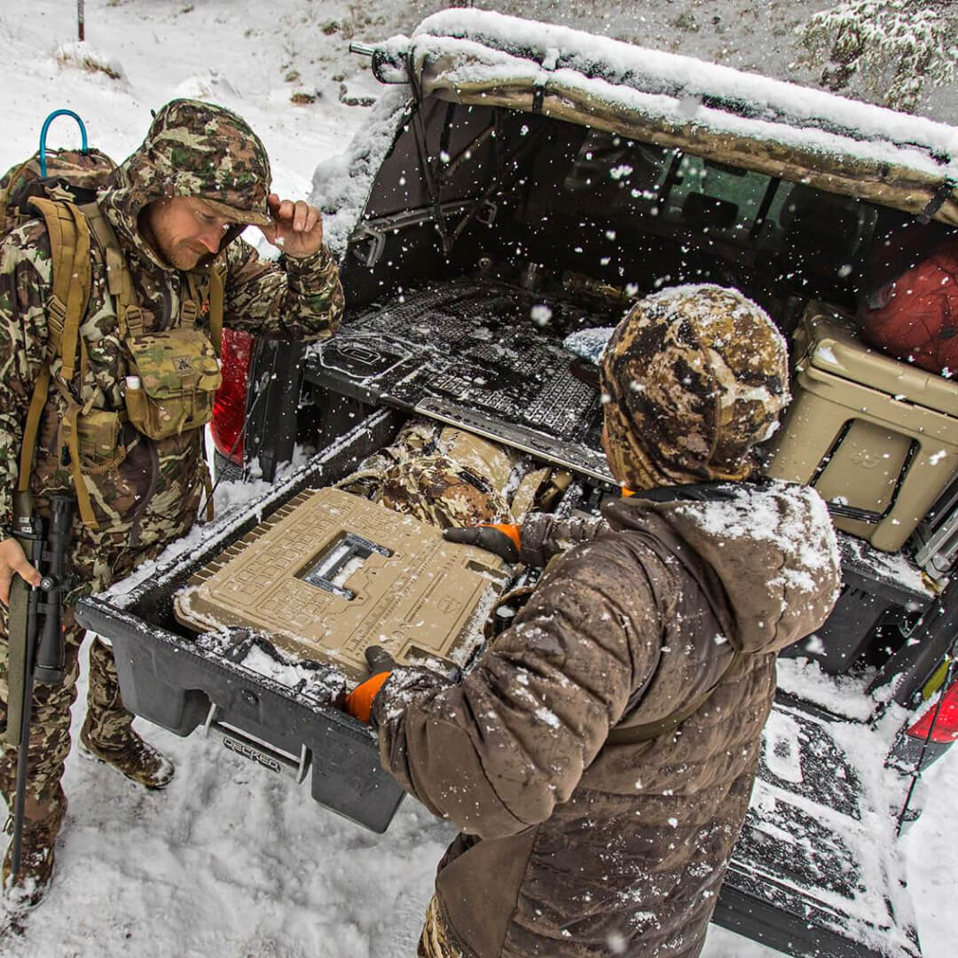 Two hunters reaching for their gear being stored in a Drawer System
