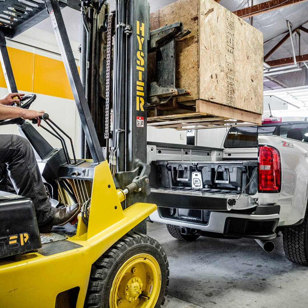 Forklift putting a large wood pallet on the back of a Drawer System