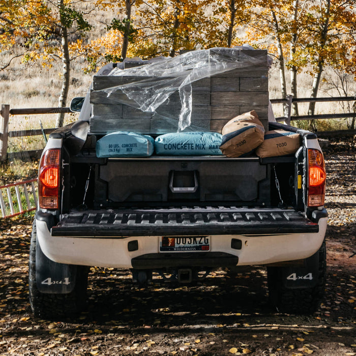 concrete bricks and bags of concrete sitting in the bed of a truck on top of a drawer system