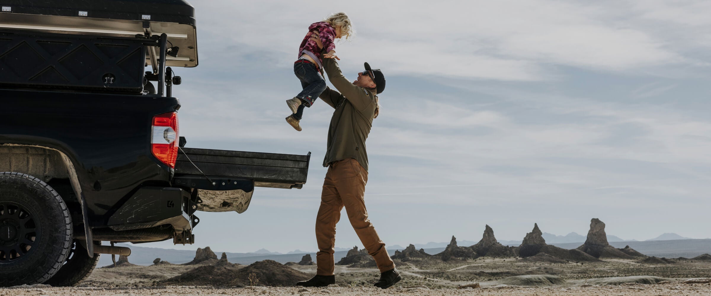 A dad lifting his daughter into the air.