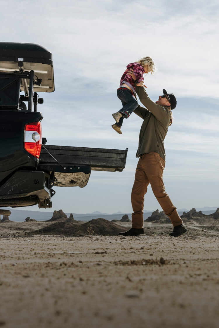 A dad lifting his daughter into the air.