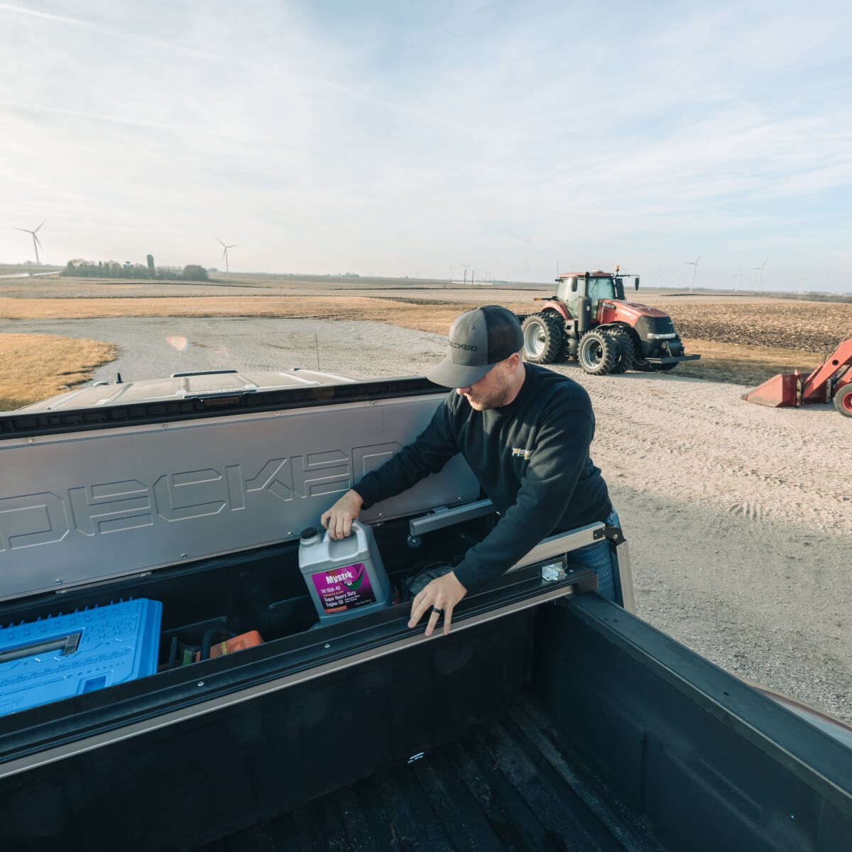 man accessing tools in the back of a decked tool box