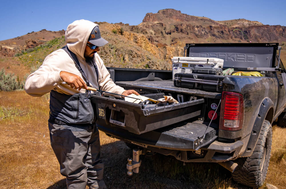 person accessing their fishing gear in the back of their decked drawer system