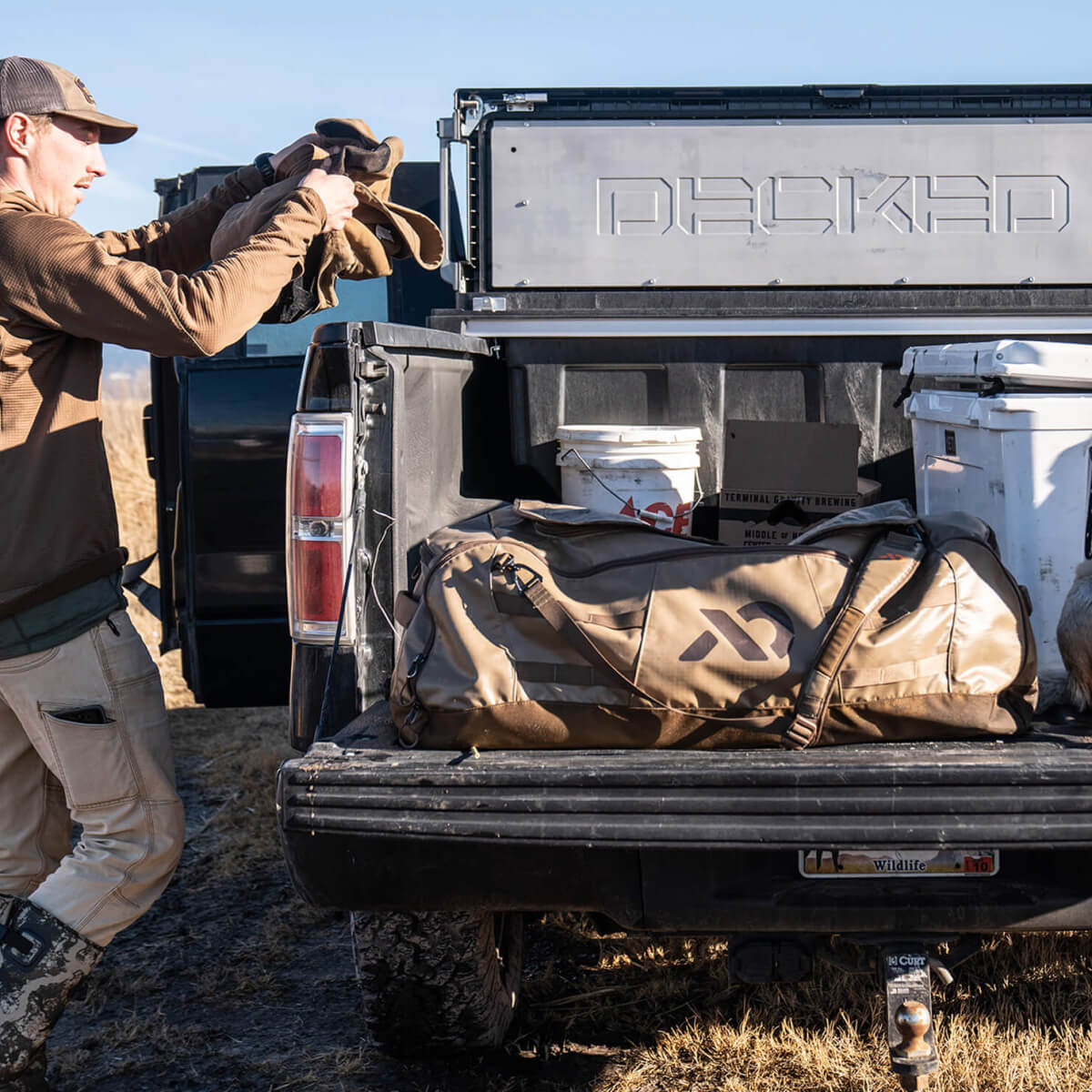 Man putting hunting gear in his decked tool box