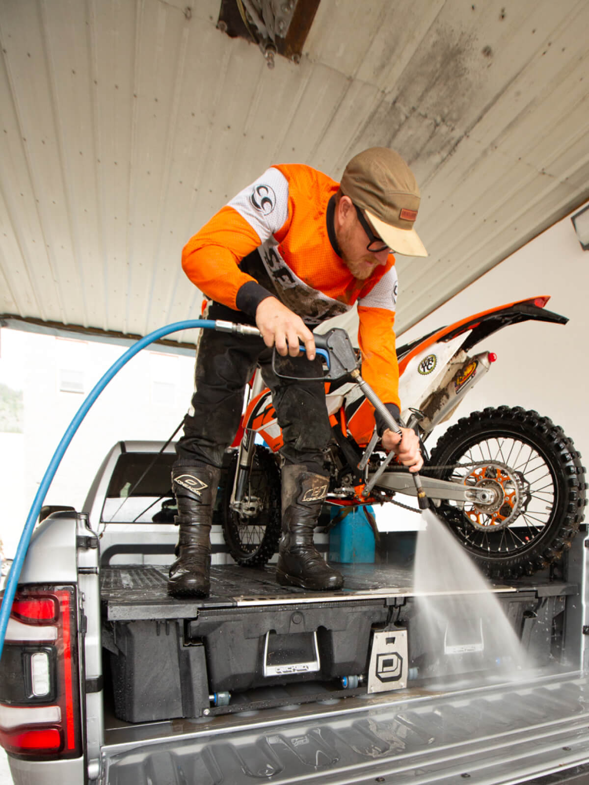 Man hosing down his drawer system after going dirt biking