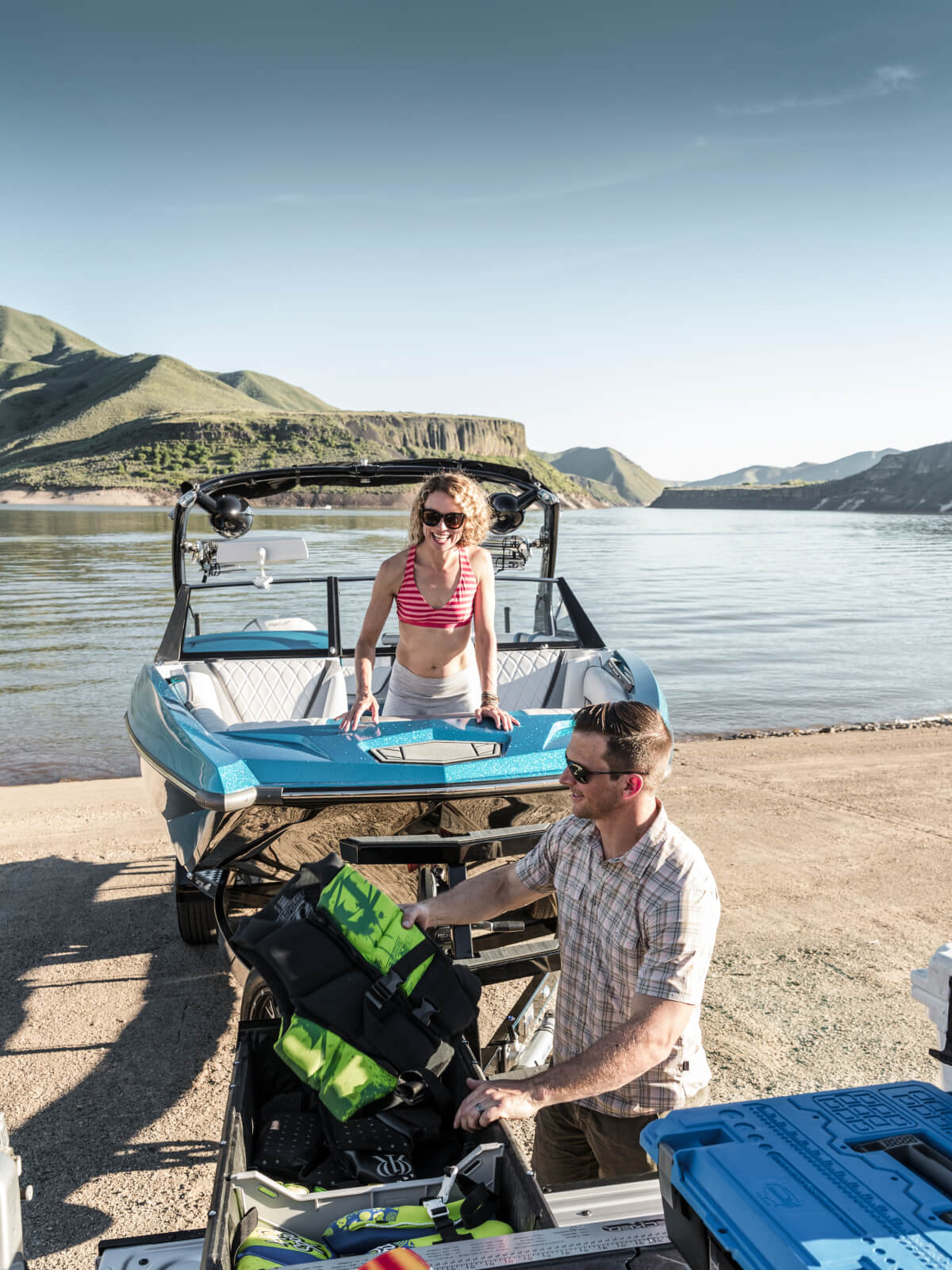 man pulling life jackets out of a drawer system at a boat ramp
