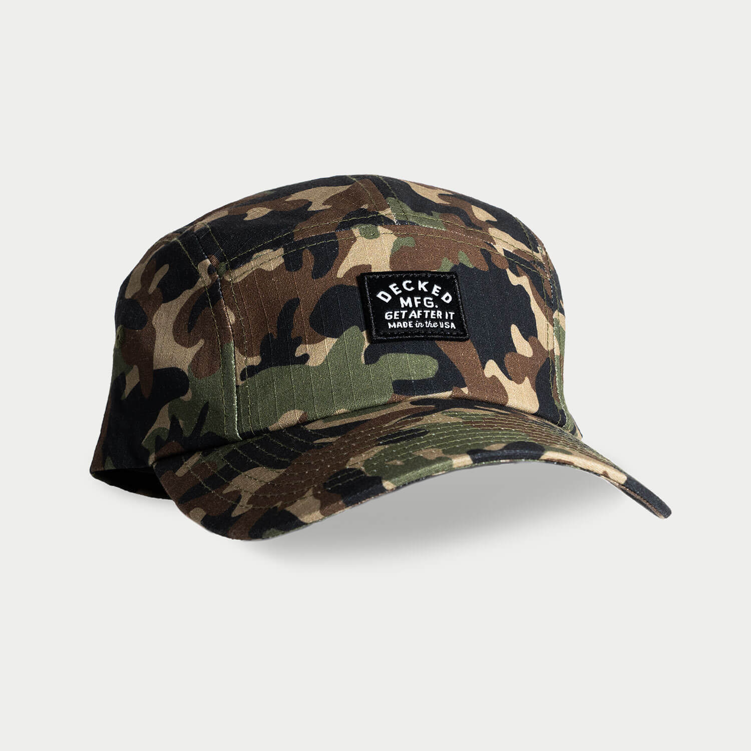 A green, brown and black 5-panel hat that has a small DECKED patch that says GET AFTER IT and Made in the USA.