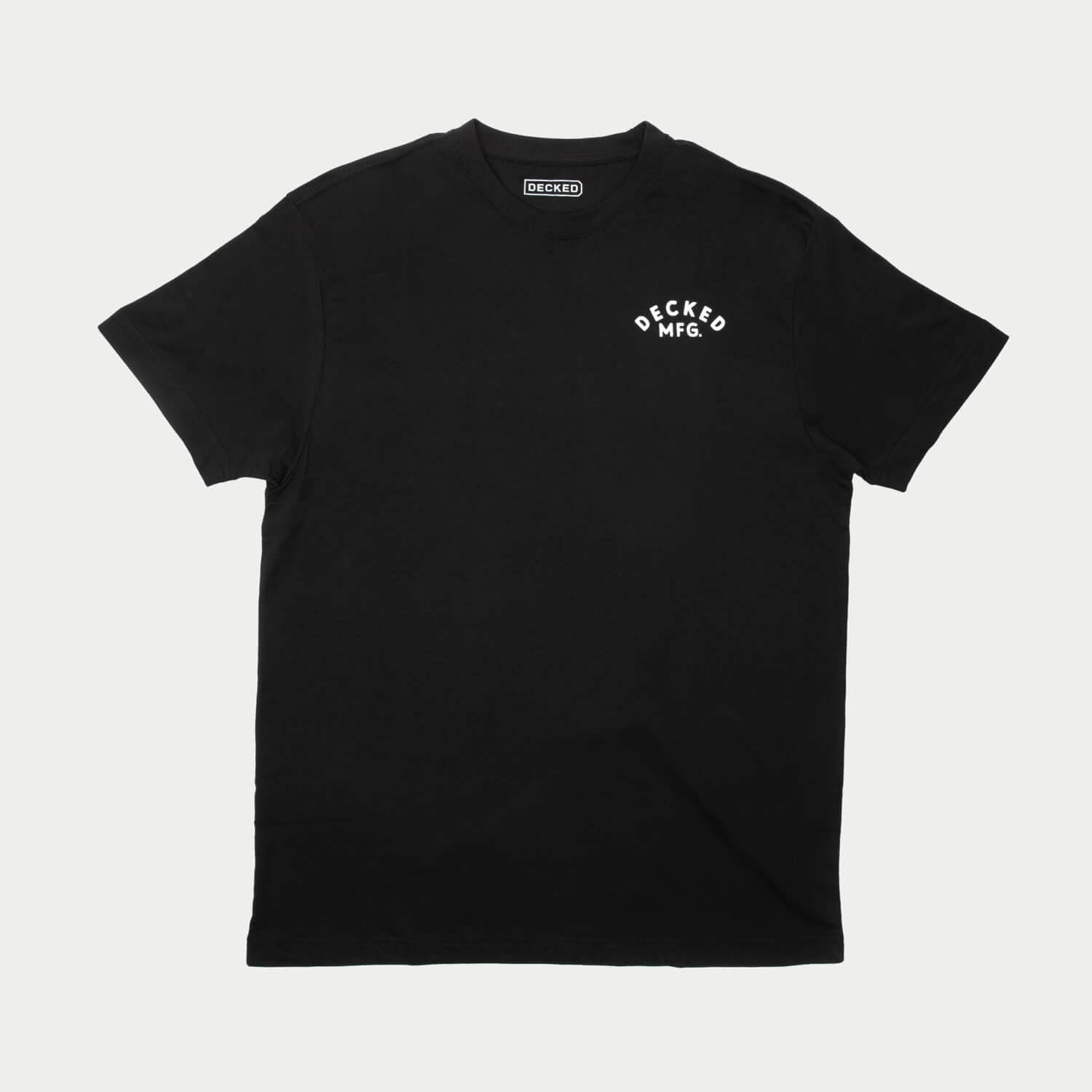 Black t-shirt with a small white logo that says DECKED MFG. the shirt is on a light gray background